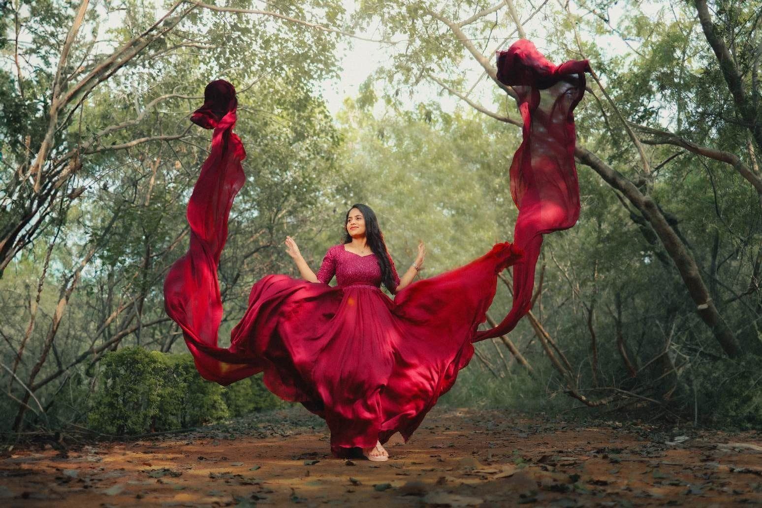Woman in a flowing red gown in a forest